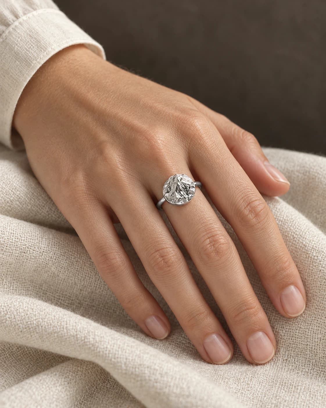 Sterling silver terrain ring worn on a hand, with a mountain landscape on its round face