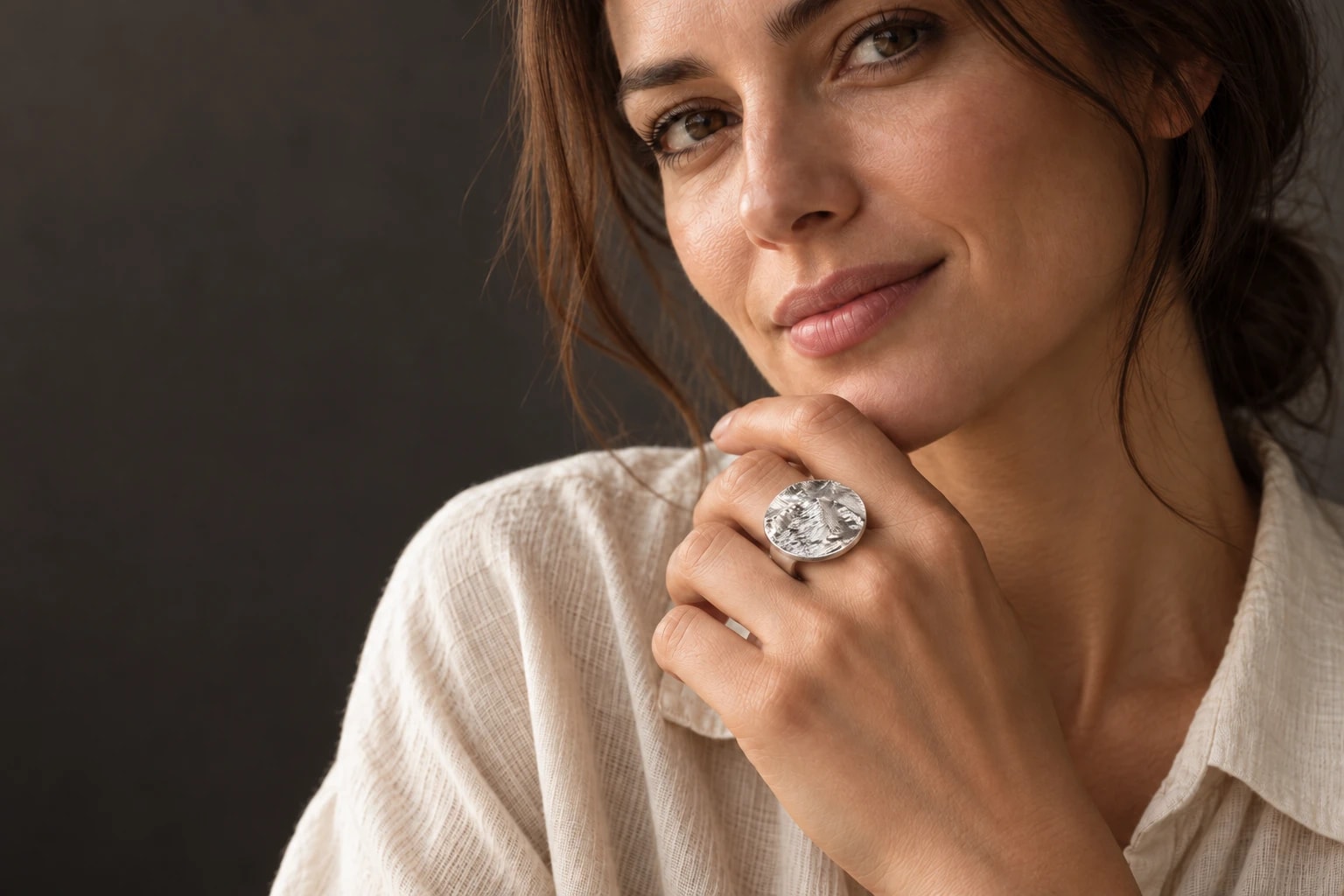 Woman wearing a sterling silver Statement Disc ring shaped by Mount Assiniboine, Canada